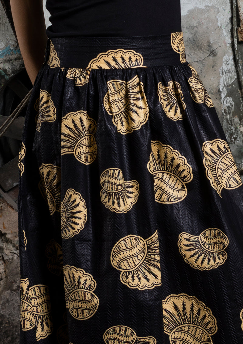 Cora & Lea-woman-long skirt Suzanne. African Wax-Print, black print and cream with shell motifs. 