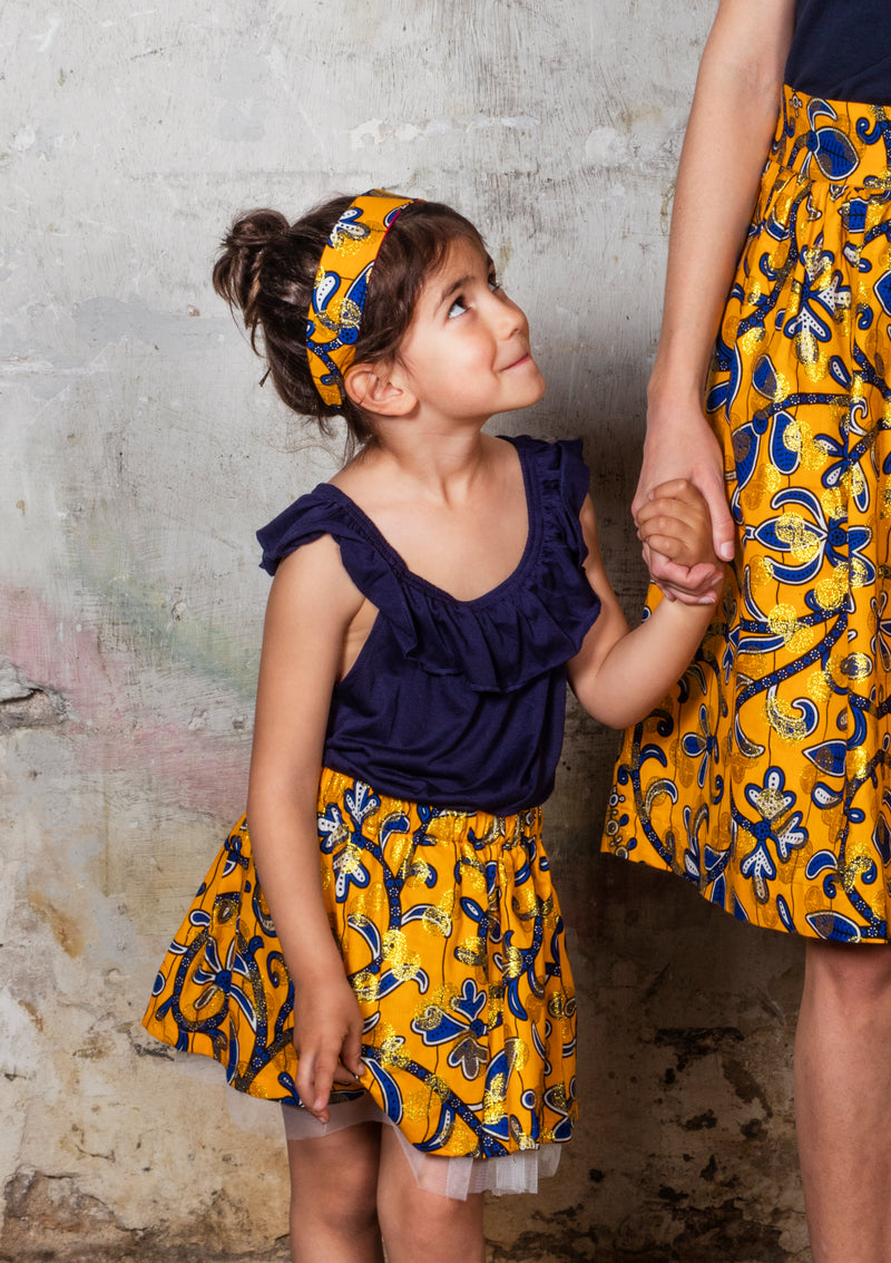Cora & Lea - Niña- falda Twist and Shout. African Wax-Print, Estampado amarillo, azul y dorado. 