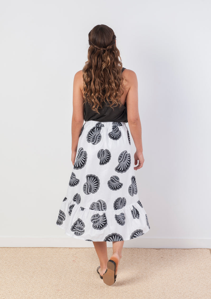 Cora & Lea-woman-asymmetric Jagger skirt. African Wax-Print, black and white prints with sea shells. 